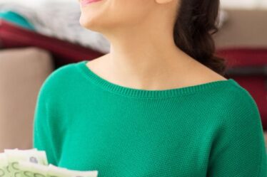 investeren, lendahand, snel sparen besparen beleggen financieel buffer en spaargeld - een vrouw houdt het geld vast