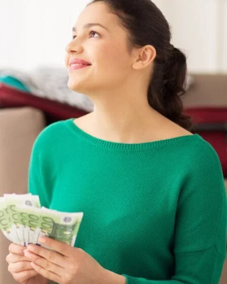 investeren, lendahand, snel sparen besparen beleggen financieel buffer en spaargeld - een vrouw houdt het geld vast