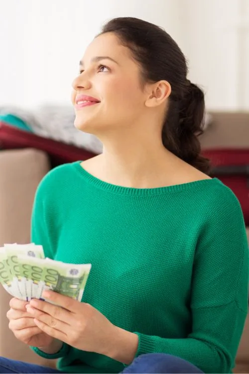 investeren, lendahand, snel sparen besparen beleggen financieel buffer en spaargeld - een vrouw houdt het geld vast