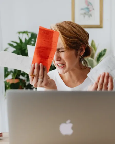 Geldstress bij dame achter haar laptop die eerst snel geld wilde lenen maar zich toch bedenkt na het lezen van de blog over de risico's en regels daarvan