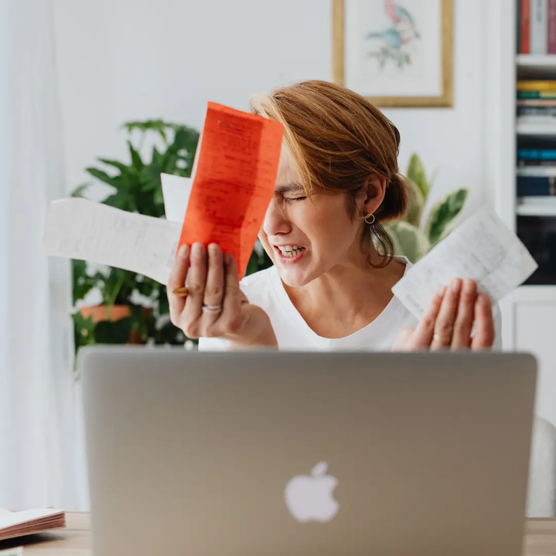 Geldstress bij dame achter haar laptop die eerst snel geld wilde lenen maar zich toch bedenkt na het lezen van de blog over de risico's en regels daarvan