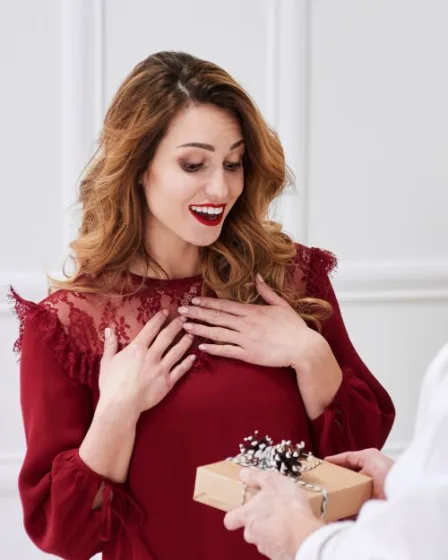 Vrouw kijkt verrast maar wist eigenlijk wel dat dit cadeautje eraan zat te komen. Dat stond op haar wensenlijstje.