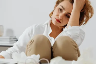 Vrouw staart verdrietig voor haar uit, haar man is overleden en ze heeft geldstress, ze weet niets van en over de financiën