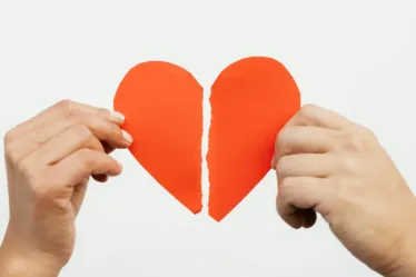 Een gebroken of verscheurd hart of een relatie, man en vrouw houden een helft vast, scheiden