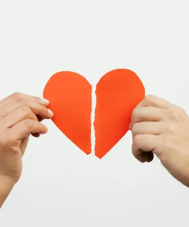 Een gebroken of verscheurd hart of een relatie, man en vrouw houden een helft vast, scheiden