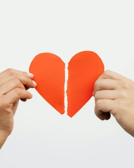 Een gebroken of verscheurd hart of een relatie, man en vrouw houden een helft vast, scheiden